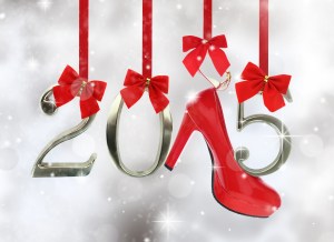 High heel shoe and 2015 number hanging on red ribbons in a glitt
