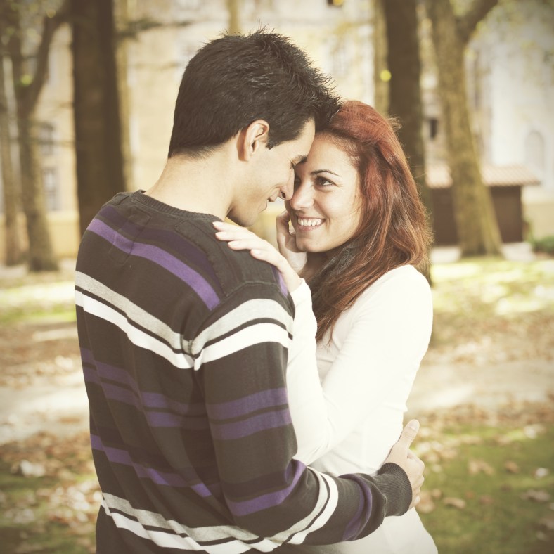 Love and affection between a young couple at the park in autumn